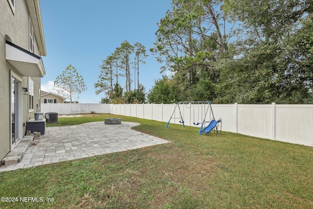 view of yard featuring a patio, a playground, and central air condition unit