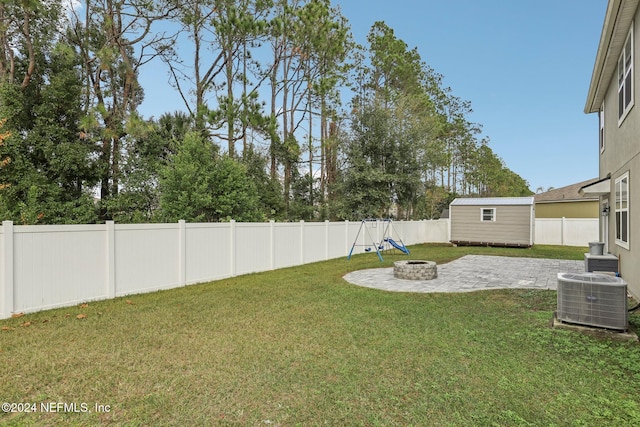 view of yard with central AC unit, a storage shed, an outdoor fire pit, and a patio