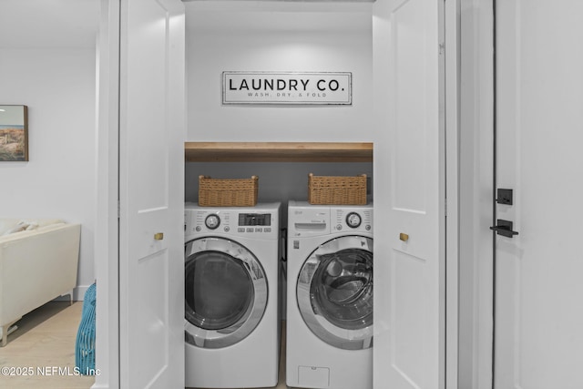 laundry area featuring light hardwood / wood-style flooring and washing machine and dryer