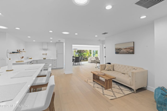 living room featuring ornate columns and light wood-type flooring