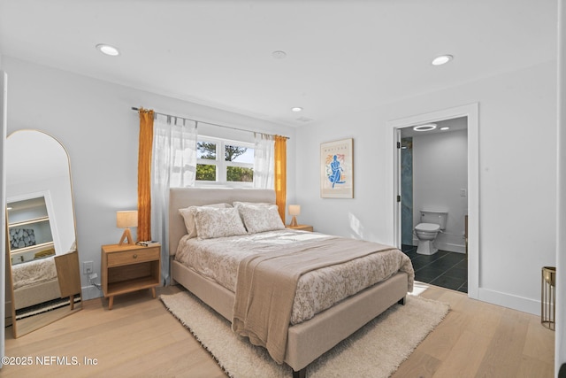 bedroom featuring connected bathroom and light hardwood / wood-style floors