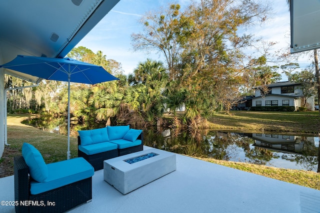 view of patio / terrace with a water view and an outdoor living space with a fire pit