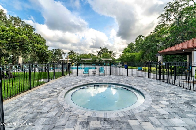 view of pool featuring a patio and an in ground hot tub