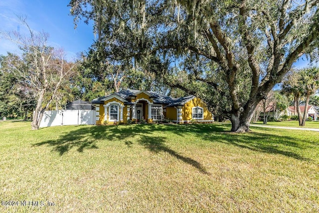 ranch-style home featuring a lanai and a front lawn