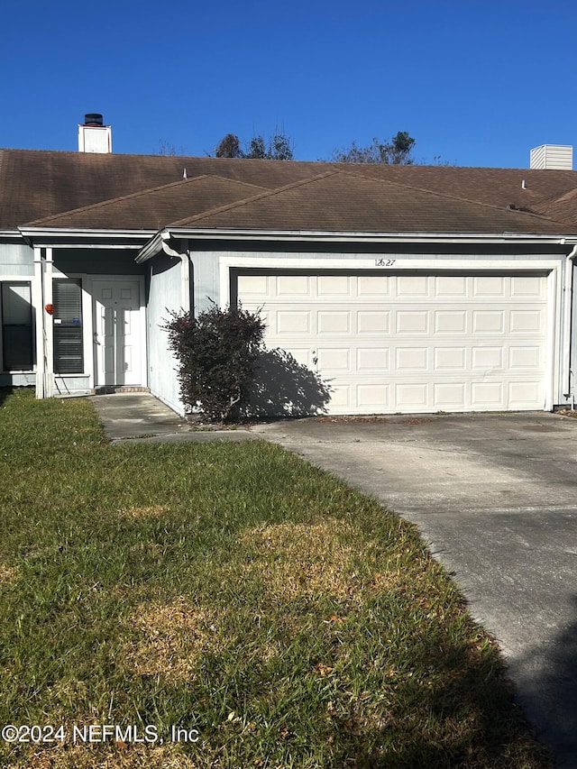 view of front of house with a front yard and a garage