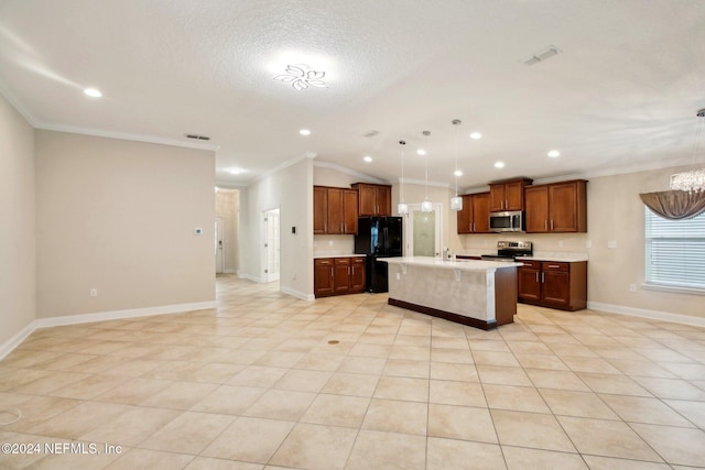 kitchen with crown molding, vaulted ceiling, an island with sink, appliances with stainless steel finishes, and decorative light fixtures