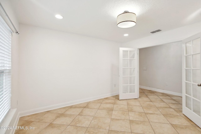 tiled empty room with french doors