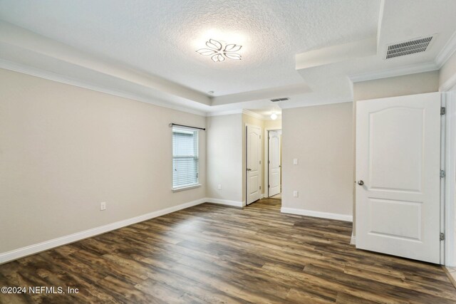 spare room with dark wood-type flooring, a textured ceiling, and ornamental molding