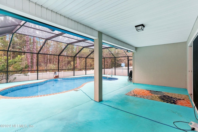 view of swimming pool featuring a patio and glass enclosure