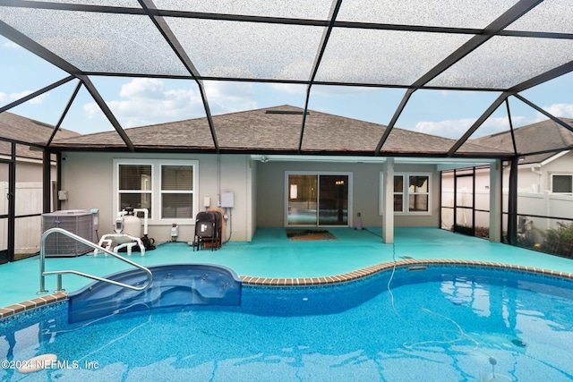 view of pool with a lanai, a patio, and central AC unit