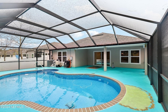 view of swimming pool with a patio, glass enclosure, and central air condition unit