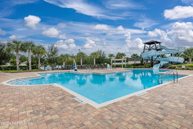 view of swimming pool with a patio area and a water slide