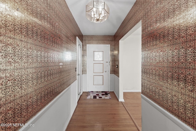 corridor featuring hardwood / wood-style floors and a chandelier