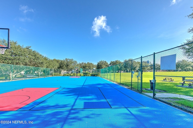 view of sport court featuring a lawn