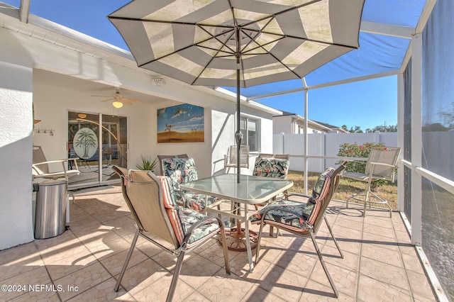 view of patio featuring glass enclosure and ceiling fan