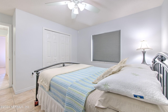 bedroom with ceiling fan, a closet, and light tile patterned floors