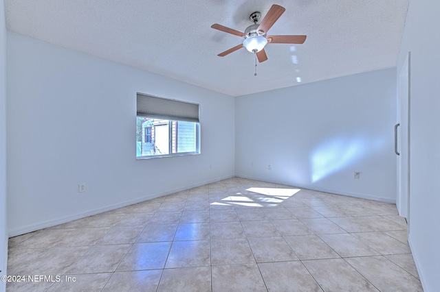 tiled spare room with ceiling fan and a textured ceiling