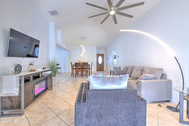 living room featuring ceiling fan, light tile patterned flooring, and lofted ceiling