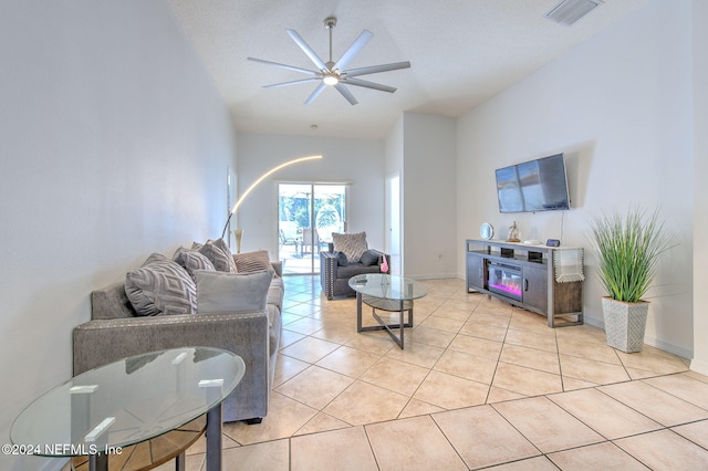 tiled living room with ceiling fan and a textured ceiling