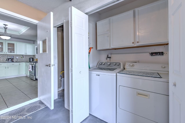 laundry room with separate washer and dryer, light tile patterned floors, and cabinets