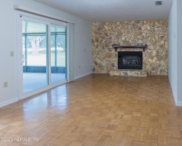 unfurnished living room with a fireplace and light parquet flooring