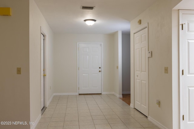 hall with light tile patterned floors