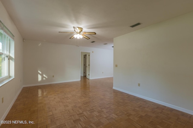 empty room featuring ceiling fan and parquet flooring