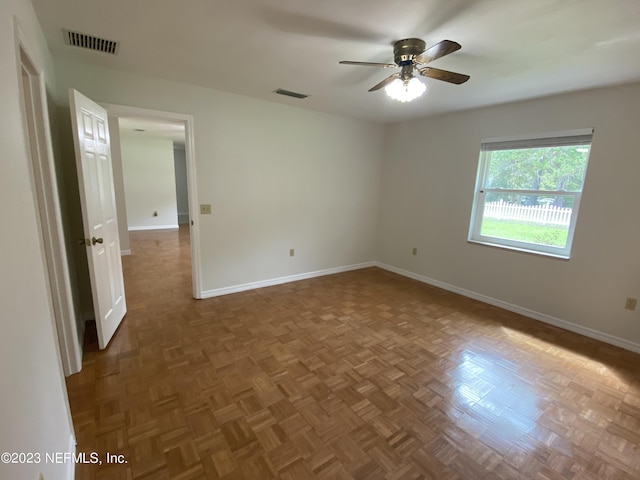 spare room with dark parquet flooring and ceiling fan