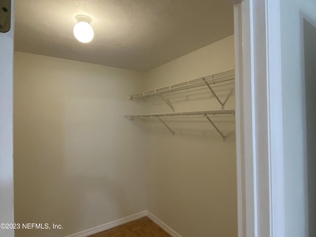 walk in closet featuring parquet floors