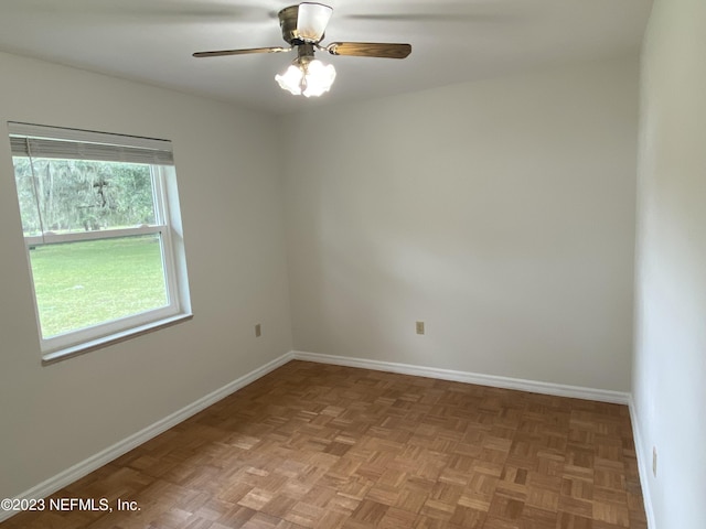 spare room with ceiling fan and light parquet flooring