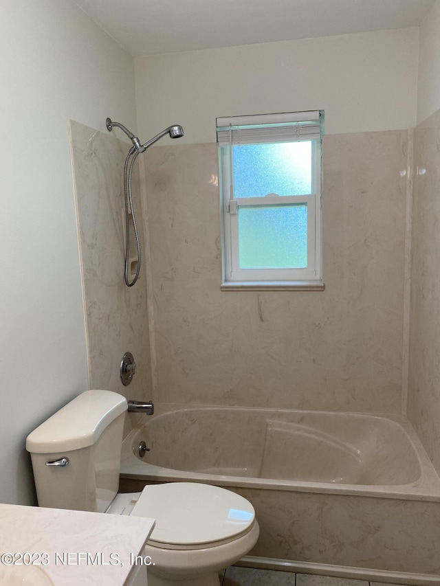 full bathroom with vanity, tiled shower / bath combo, and toilet