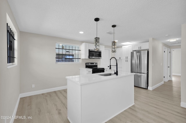 kitchen with white cabinetry, sink, hanging light fixtures, stainless steel appliances, and light hardwood / wood-style floors