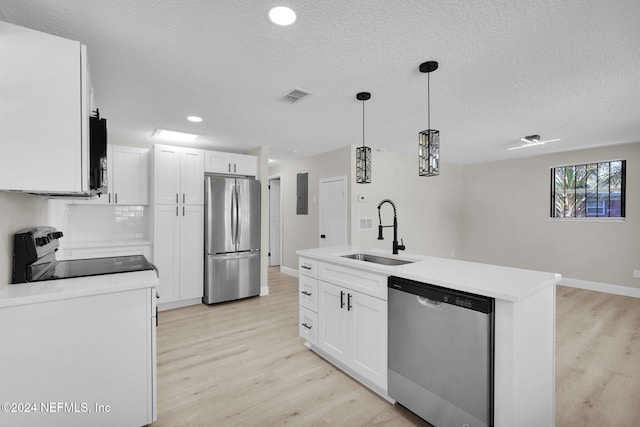 kitchen featuring pendant lighting, white cabinets, sink, an island with sink, and appliances with stainless steel finishes