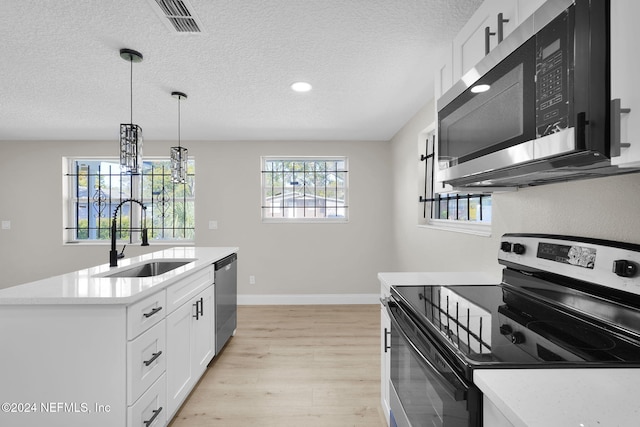 kitchen with plenty of natural light, white cabinetry, sink, and appliances with stainless steel finishes