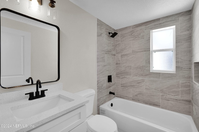 full bathroom with a textured ceiling, vanity, toilet, and tiled shower / bath