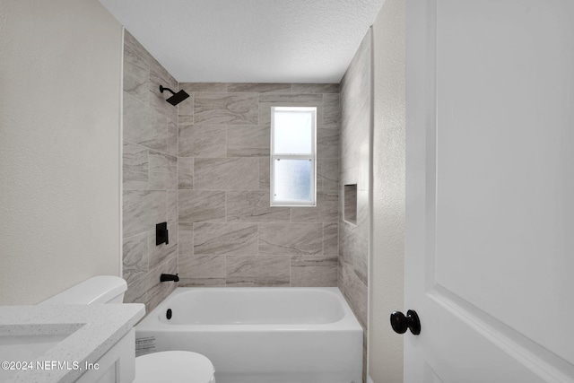 full bathroom featuring tiled shower / bath combo, toilet, a textured ceiling, and vanity