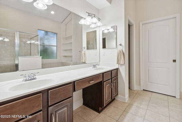 bathroom with tile patterned flooring, vanity, and a shower with door