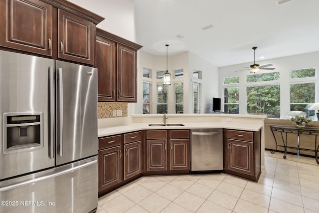 kitchen featuring sink, decorative backsplash, ceiling fan, appliances with stainless steel finishes, and dark brown cabinets