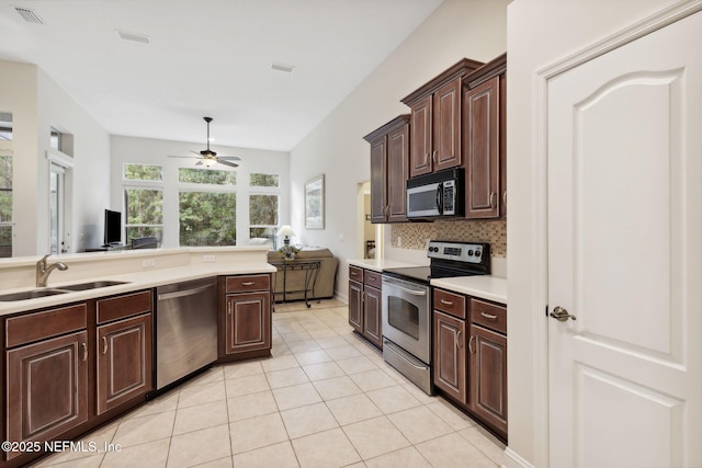 kitchen featuring dark brown cabinetry, ceiling fan, sink, decorative backsplash, and appliances with stainless steel finishes