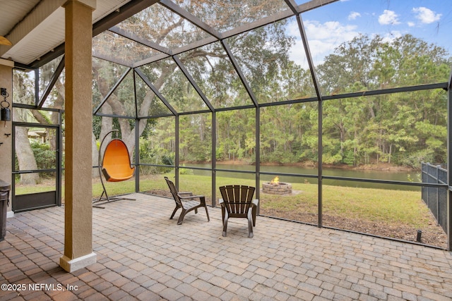 view of patio featuring a lanai and a water view