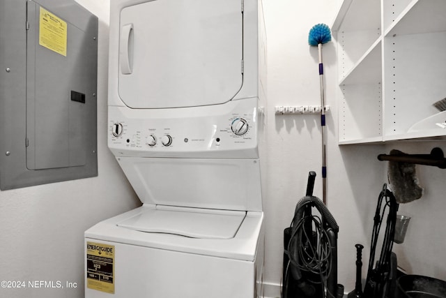 laundry room with electric panel and stacked washing maching and dryer