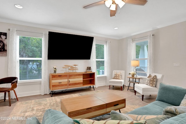 living room featuring wood-type flooring, ceiling fan, and crown molding