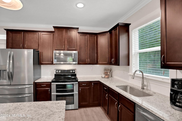 kitchen featuring a wealth of natural light, ornamental molding, sink, and appliances with stainless steel finishes