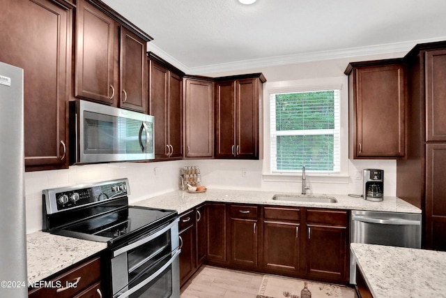 kitchen with light stone countertops, sink, crown molding, dark brown cabinets, and appliances with stainless steel finishes