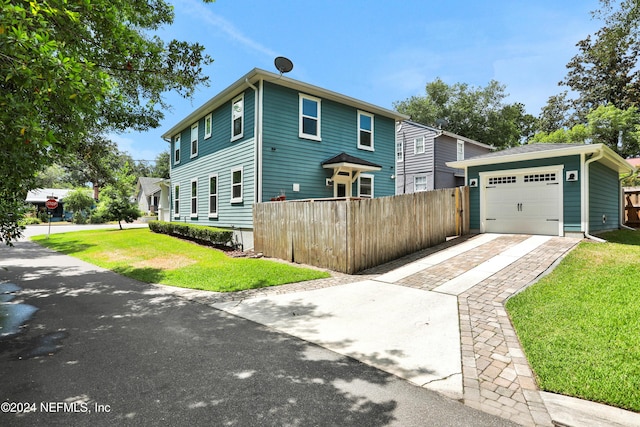 view of front of home featuring an outbuilding, a garage, and a front lawn