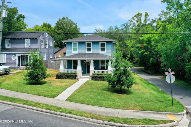 view of property featuring covered porch and a front yard