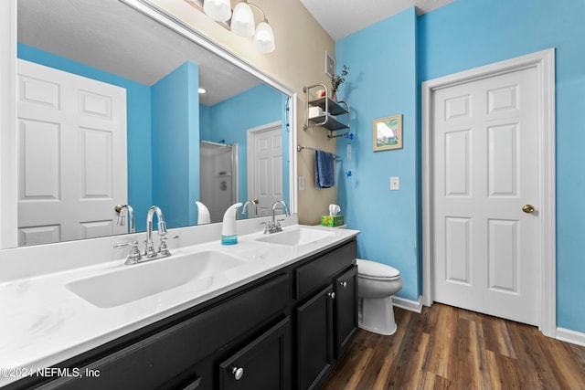 bathroom featuring walk in shower, wood-type flooring, a textured ceiling, toilet, and vanity