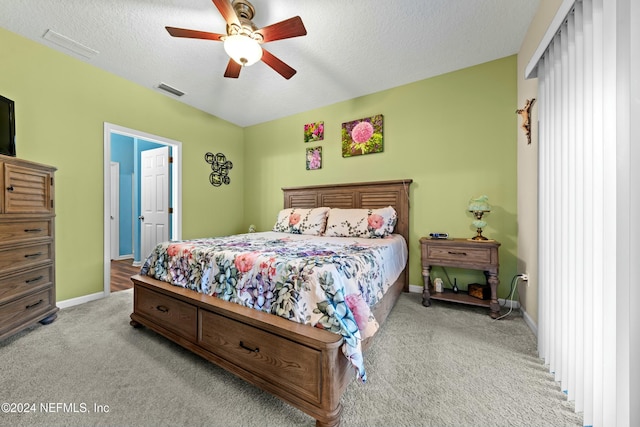 carpeted bedroom featuring a textured ceiling and ceiling fan