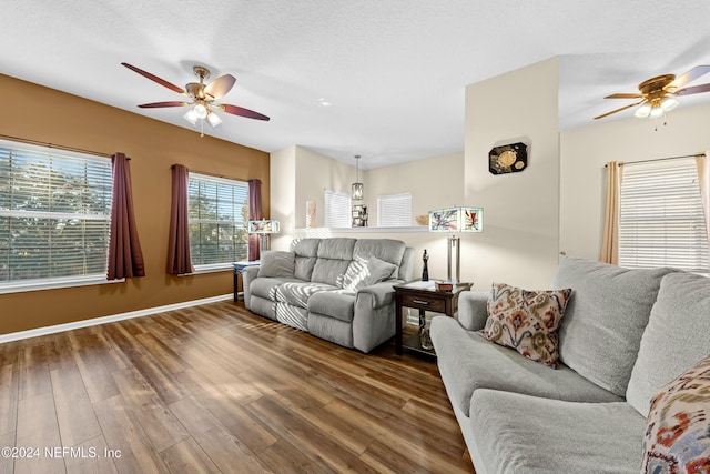 living room with ceiling fan, dark wood-type flooring, and a textured ceiling