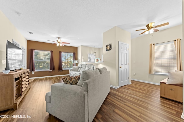 living room featuring hardwood / wood-style floors, a textured ceiling, and ceiling fan